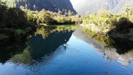 hombre remando por un impresionante río de montaña con aguas cristalinas rodeado de selva tropical y empinadas montañas amuralladas