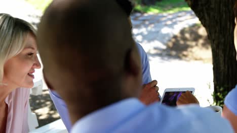 group of friends discussing over digital tablet