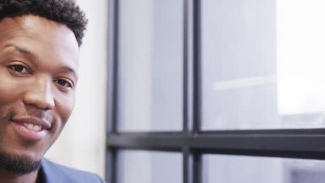portrait of happy african american male creative at casual office, with copy space, in slow motion