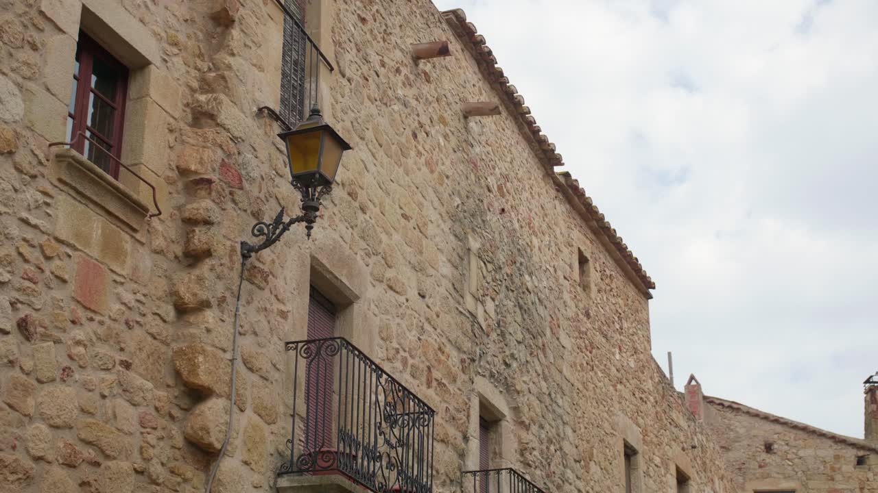arquitectura medieval de adoquines con balcón y farola antigua