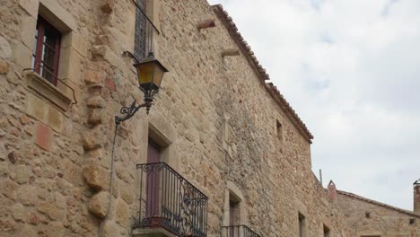 arquitectura medieval de adoquines con balcón y farola antigua