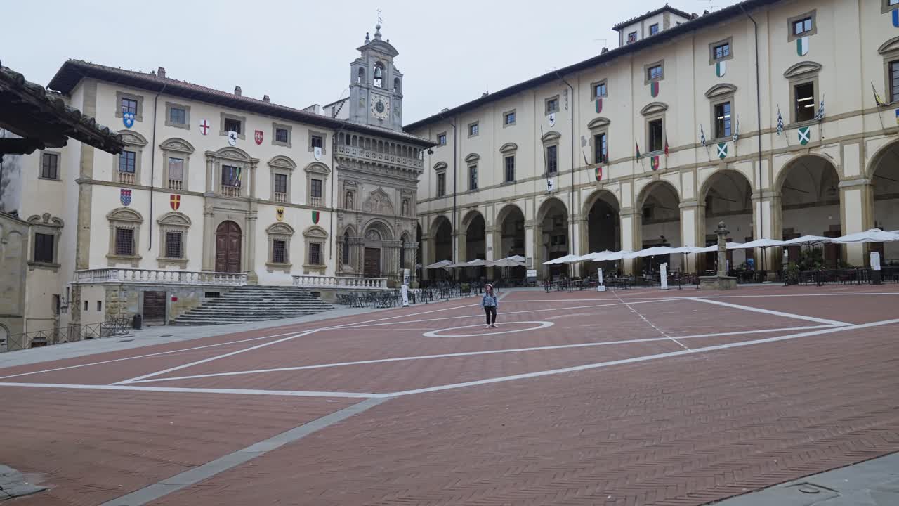 туристка в палаццо делла фратерита деи лейси на большой площади в арезцо, тоскана, италия