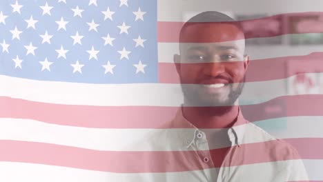 Animation-of-american-flag-over-happy-african-american-male-teacher-smiling-in-classroom