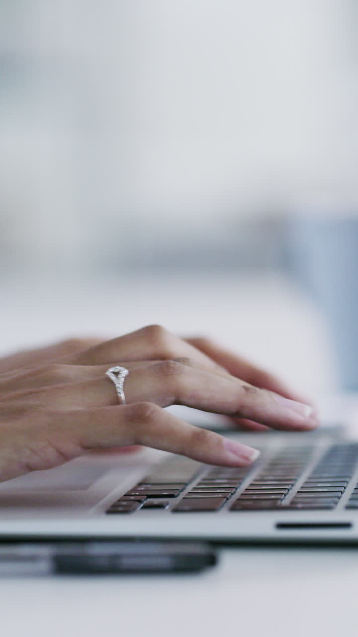 Primo piano di mani che usano uno smartphone e digitano su una tastiera di laptop.