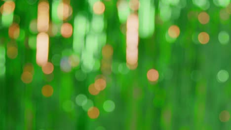 defocused full frame background shot of green and gold tinsel in studio for st patrick's day