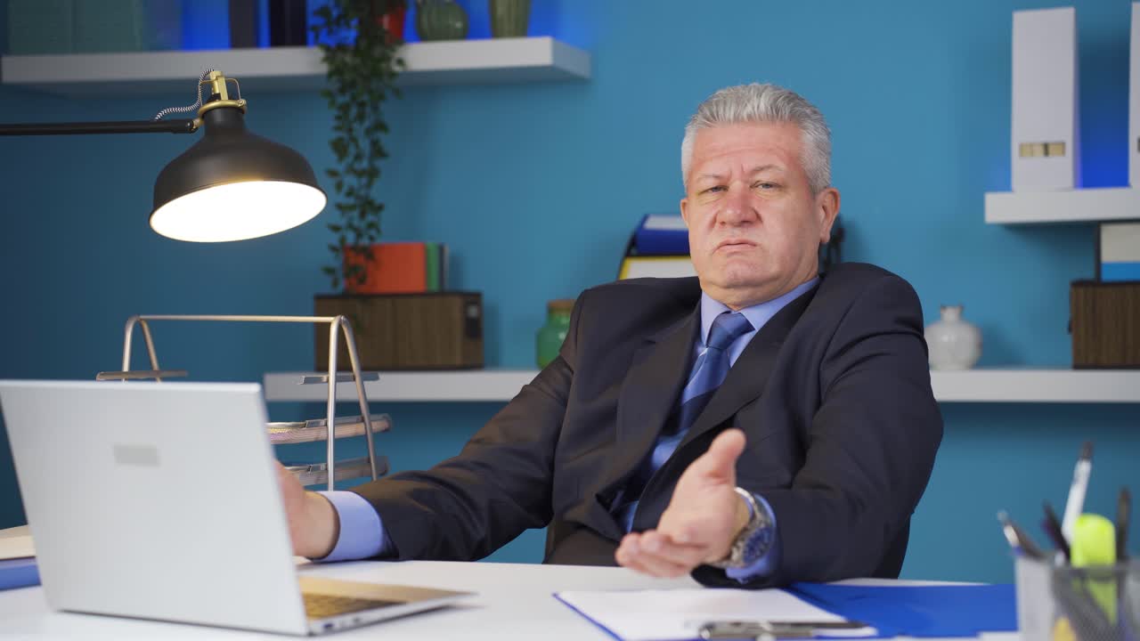 Biznesmen patrzący w kamerę, zmęczony pracą