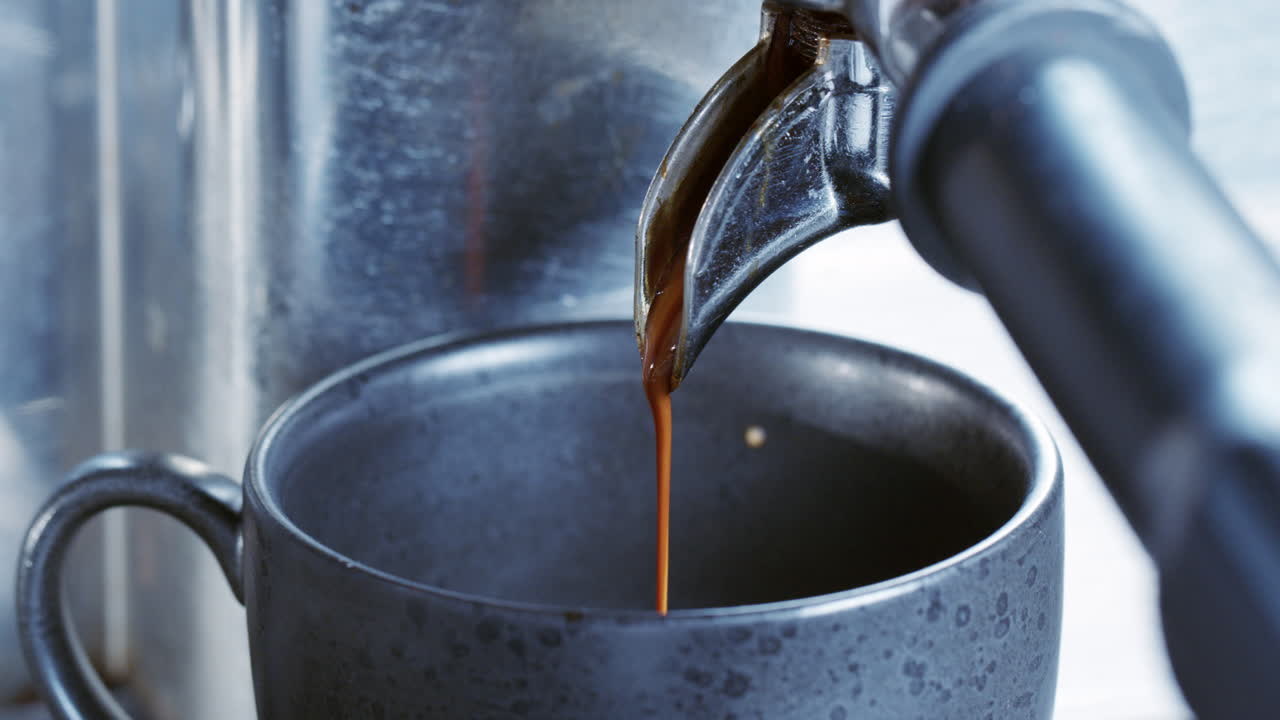 Coffee runs out of a coffee machine into a cup