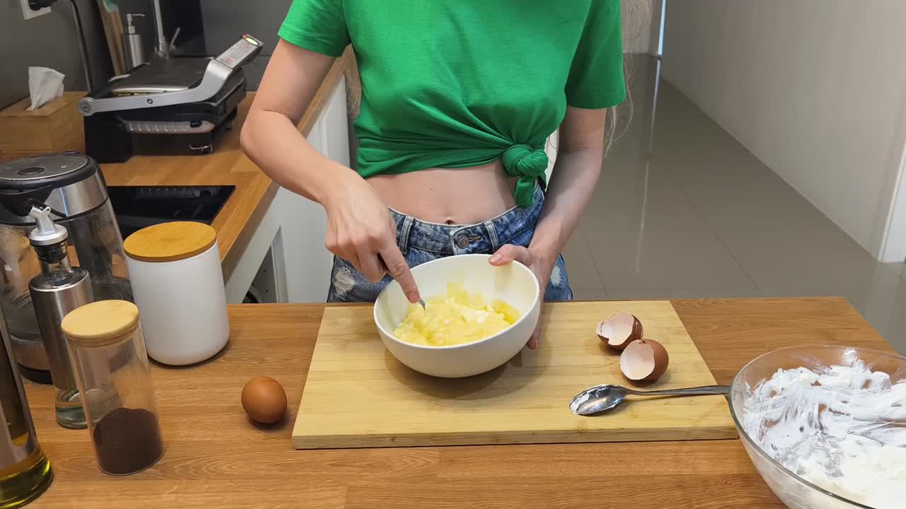 Woman cooking with eggs in the kitchen