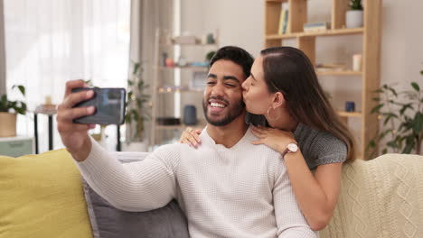 Couple,-selfie-and-living-room-sofa-with-a-kiss