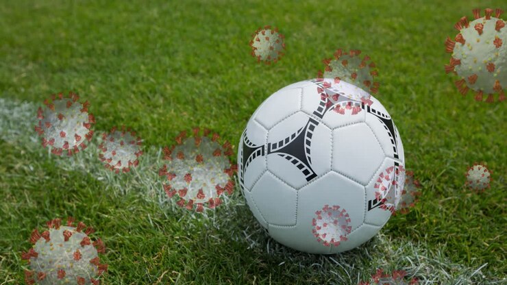 Cellule Covid-19 contro un pallone da calcio su un campo sportivo