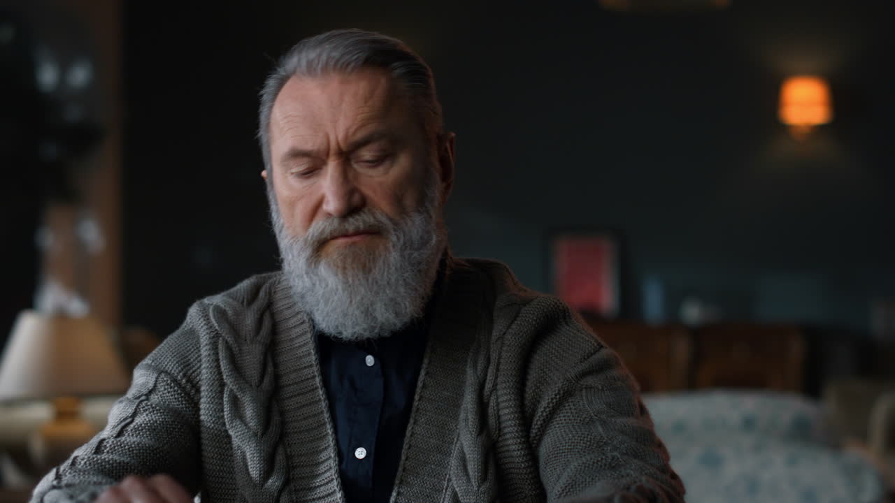 un hombre de edad avanzada que comienza a trabajar en la computadora en el interior de una casa de lujo.