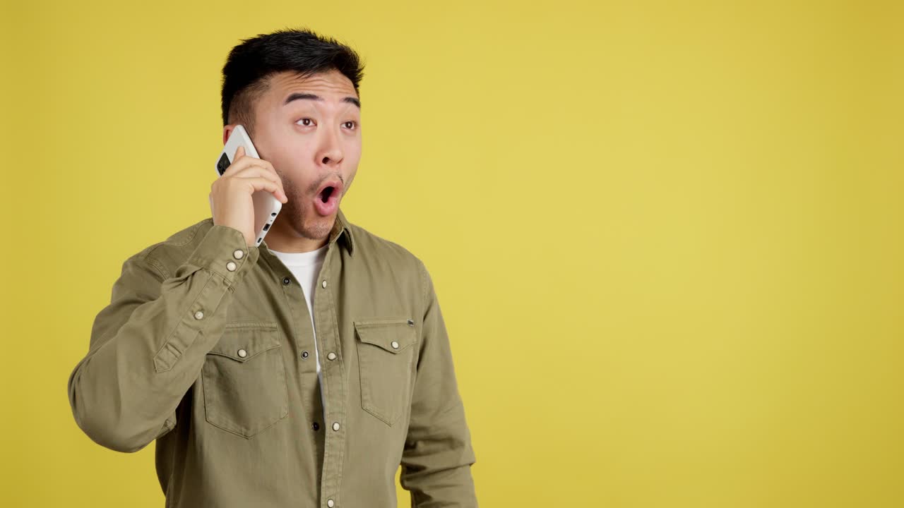 Surprised Asian Man Talking on Phone