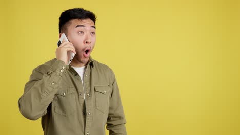 surprised asian man talking on phone