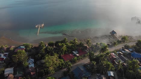an early morning drone shot of a tropical coastal village.