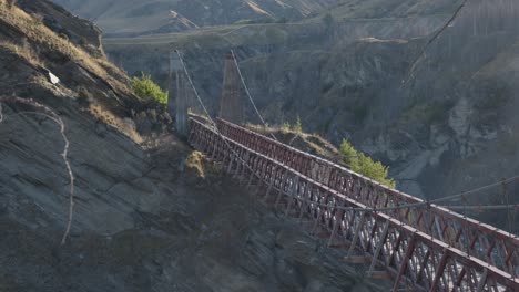 an old bridge above a valley on a sunny summer day at skippers canyon, queenstown, new zealand.