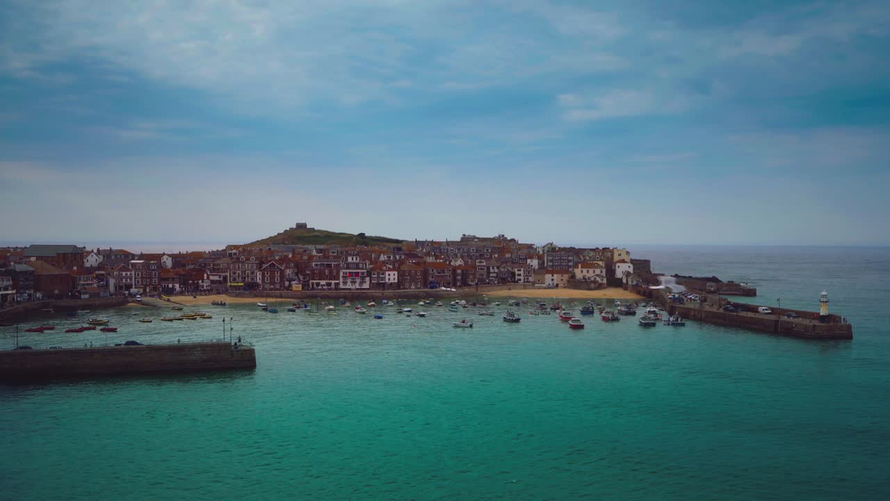 영국 남부의 코른월의 유명한 올드 타운 세인트 아이브스의 해변과 항구 산책로의 시네마그래프 (cinemagraph) 의 완벽한 비디오 루프는 오래된 관광 여행 휴가 마을 마을의 은 파란 바물에서 움직이는 어선과 함께.