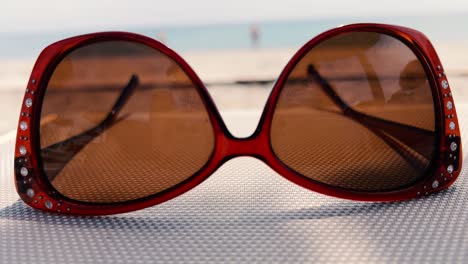 Close-up-of-classic-sunglasses-on-sunbed