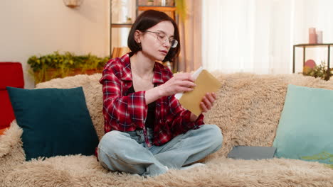 woman writing heartfelt letter on paper at home smiling with emotion before sealing it in envelope