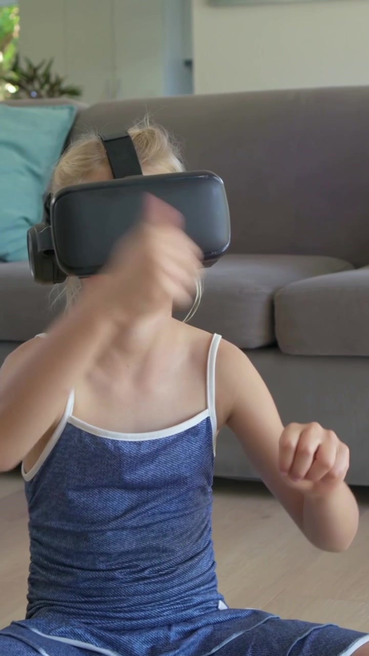 Girl in VR headset making gestures and initiating animated tech objects for play, ending on pillow