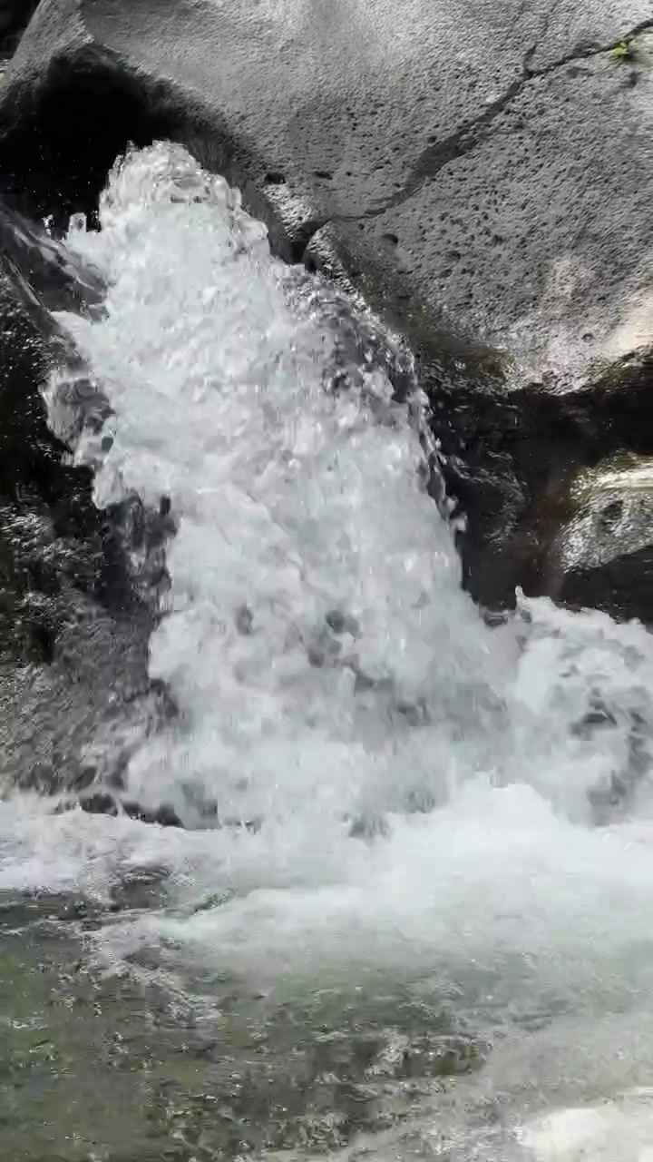 Piccola cascata che scende su rocce vulcaniche scure