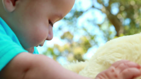 adorable niño jugando con un oso de peluche