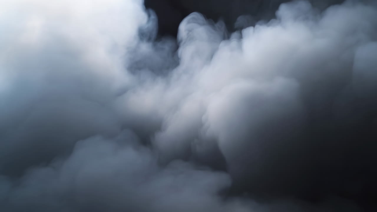 Nuvole dense di fumo bianco che turbinano su uno sfondo scuro