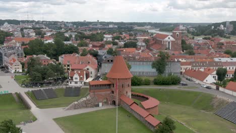 aerial drone shot of kaunas castle (kauno pilis) with skyline of kaunas city in the background. city panorama