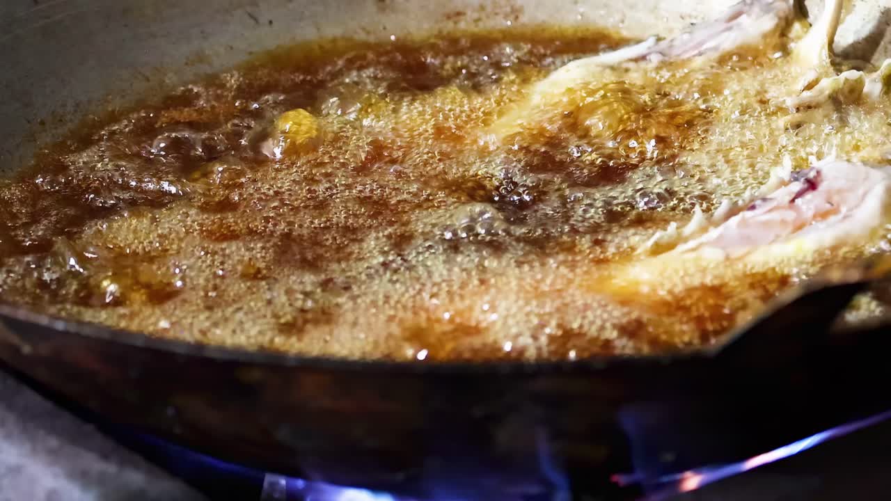 pescado frito uniformemente en aceite caliente burbujeante