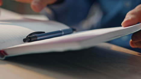 closeup businessman hands writing notes at desk. man preparing schedule notebook