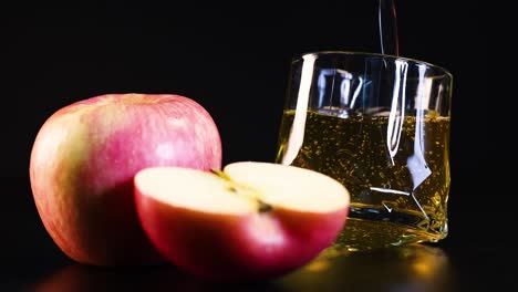 jugo de manzana derramado junto a manzanas enteras y cortadas en rodajas