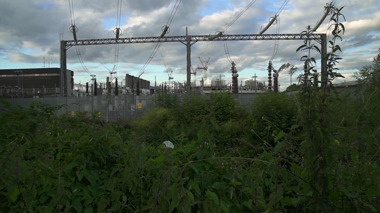 Tilt up on a power station with power lines and electricity cables