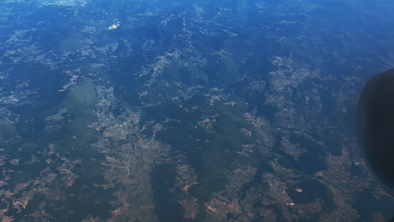 vista aérea de las montañas y el campo desde la ventana del avión