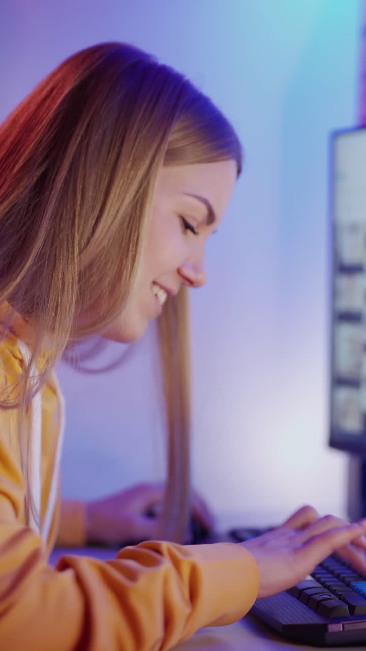 Happy woman using computer. Young happy woman sitting at home and working on computer