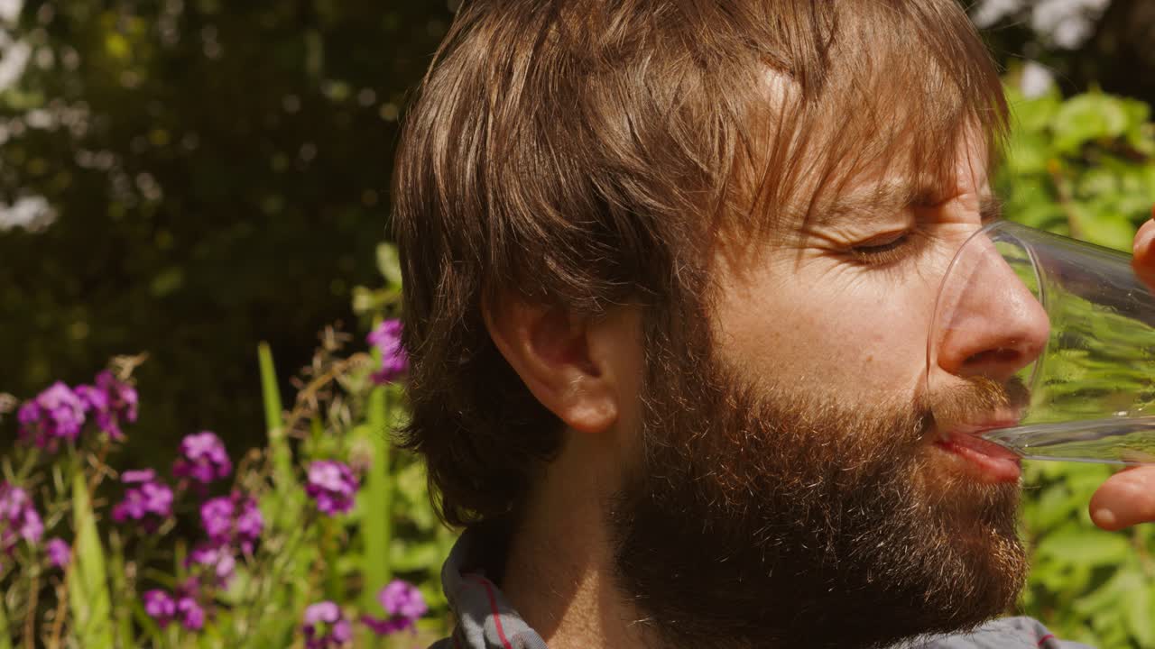 joven sediento bebiendo un vaso de agua en un día muy caluroso durante la ola de calor - cámara lenta
