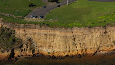 AERIAL-TILT-UP-Revealing-Coastal-Township-With-Limestone-Cliff-Faces