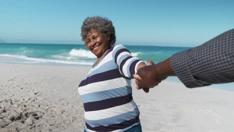 Pareja-Mayor,-Tomados-De-La-Mano,-En-La-Playa