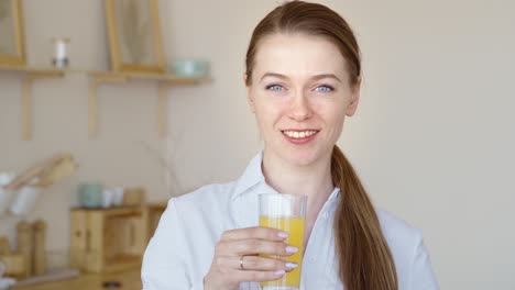una mujer bebiendo jugo de naranja.