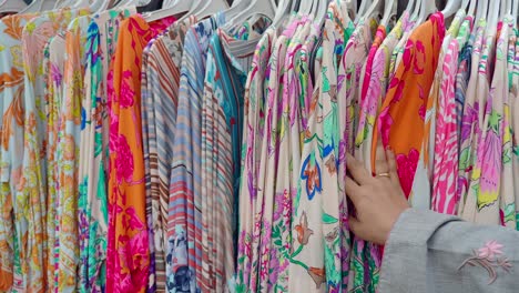 woman browsing colorful printed dresses in a store