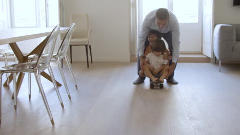 papá gracioso jugando juegos activos con sus hijos pequeños en casa