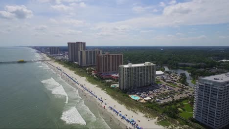 Drone-Volando-Lejos-De-La-Playa-Y-Resorts-Frente-Al-Mar-Sobre-El-Océano-En-Un-Día-Soleado