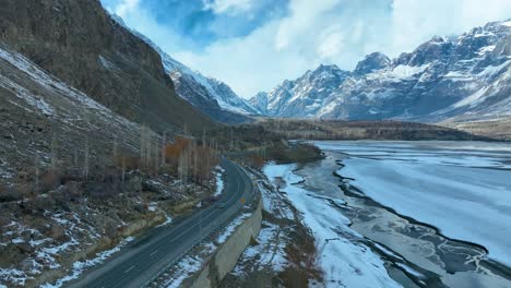 Forward-drone-shot-capturing-empty-highways-of-Skardu-with-snow-covered-peaks-of-mountain-at-background-in-Pakistan