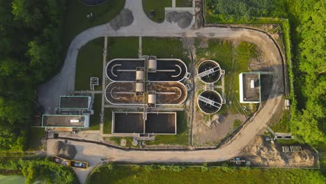 water cleaning facility surrounded with green forest, aerial top down view