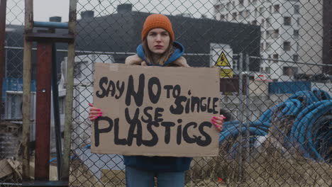 Junge-Aktivistin,-Die-Während-Eines-Protestes-Gegen-Den-Klimawandel-Ein-Plakat-Aus-Pappe-Hält,-Während-Sie-In-Die-Kamera-Blickt-4