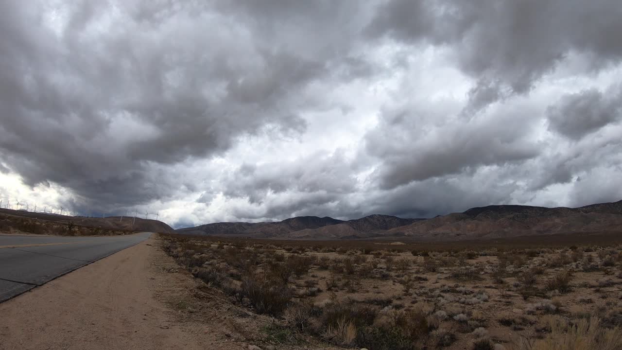 lapso de tiempo, nubes de tormenta oscuras rodando sobre las montañas del desierto de mojave por carretera