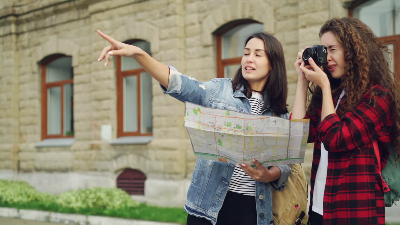 Two women exploring a city with a map and camera