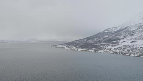 snow covered coastline in arctic along foggy kaafiord, olderdalen