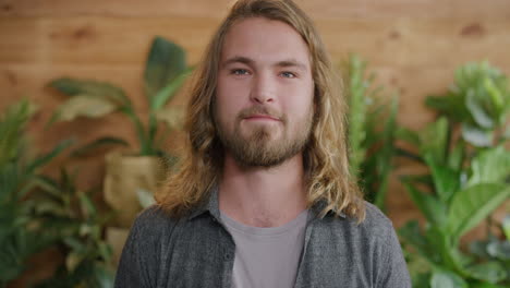 portrait of happy young blonde man smiling looking at camera with long hair attractive bearded male slow motion