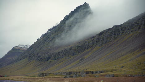 la niebla desciende rápidamente por la ladera de una montaña en islandia