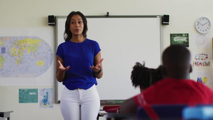 Portrait of mixed race female teacher standing in classroom conducting a lesson