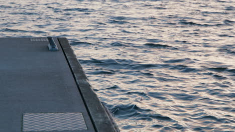 concrete jetty and sea waves in the archipelago, sunset in slow motion